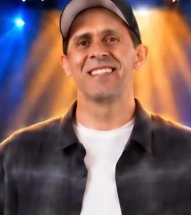 Patrick Deguire smiling under the stage lights, in a ball cap and flannel shirt